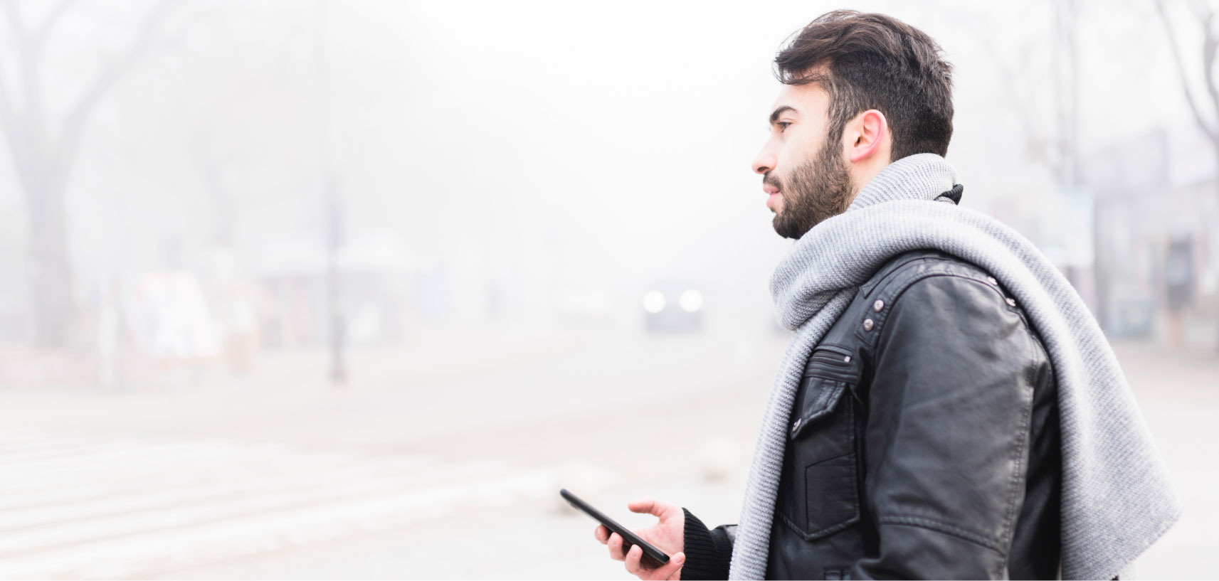 copyright: Istock/tihomir_todorov Mann mit Schal benutzt Handy